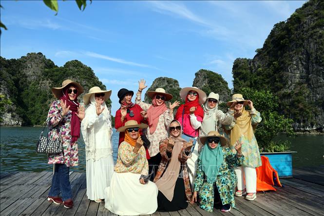 Đoàn du khách Indonesia chụp ảnh lưu niệm tại làng chài Vung Viêng. Ảnh: Đức Hiếu – TTXVN