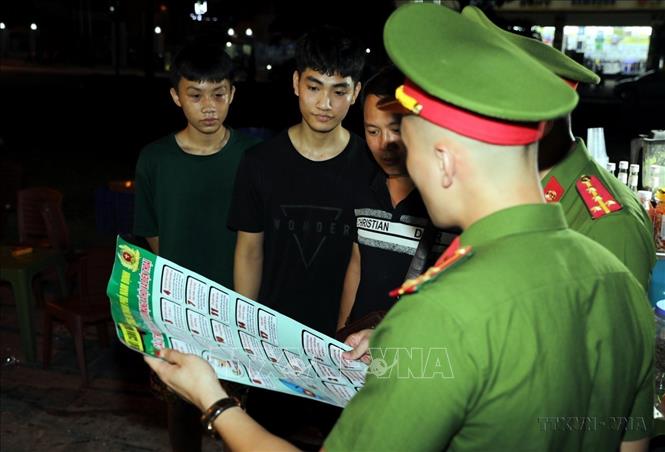 Công an thành phố Nam Định trực tiếp tuyên truyền tới người dân về việc phòng, chống lừa đảo qua mạng tại những địa điểm vui chơi buổi tối. Ảnh: Thái Thuần – TTXVN