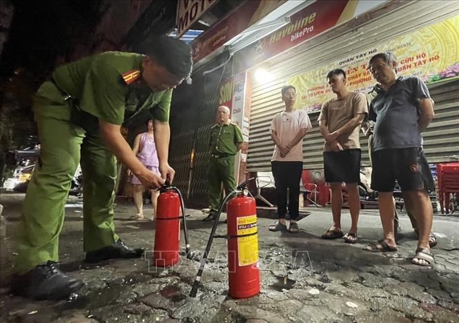 Tổ liên gia số 05, phường Bưởi, quận Tây Hồ (Hà Nội) nghe cán bộ công an hướng dẫn cách sử dụng bình chữa cháy (2023). Ảnh: Lâm Khánh - TTXVN