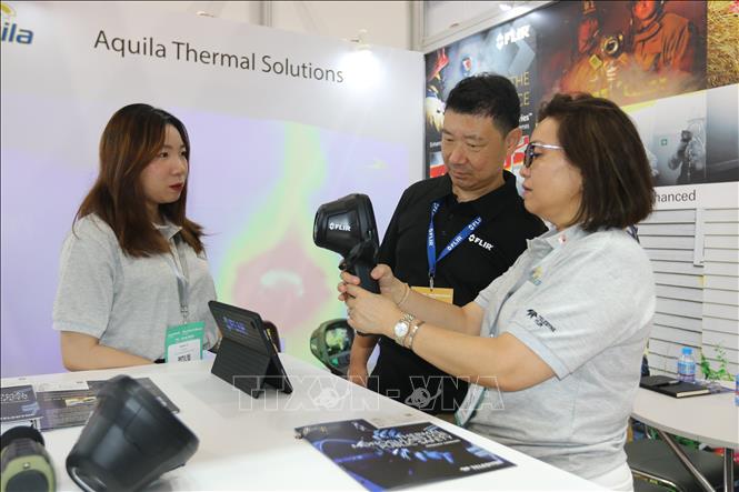 Allyson Shee, General Manager of Aquila Nova Pte. Ltd from Singapore, introduces a thermal camera that can be used to detect fire victims at the exhibition. VNA Photo: Thanh Vũ