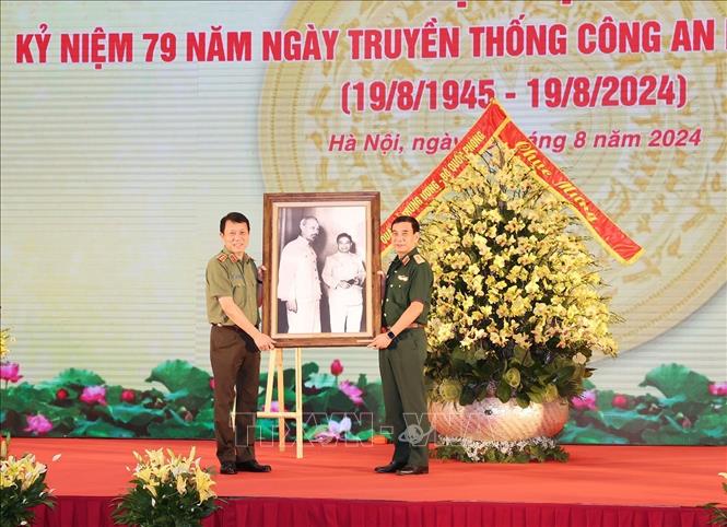 Đại tướng, Bộ trưởng Quốc phòng Phan Văn Giang, thay mặt Quân ủy Trung ương, Bộ Quốc phòng trao tặng bức ảnh Bác Hồ cho Thượng tướng, Bộ trưởng Công an Lương Tam Quang, thay mặt Đảng ủy Công an Trung ương, Bộ Công an. Ảnh: Trí Dũng – TTXVN
