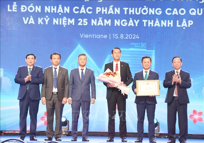 Phó Thống đố Ngân hàng Nhà nước Việt Nam Đào Minh Tú (ngoài cùng, bên phải) tặng Bằng khen cho LaoVietBank. Ảnh: Xuân Tú - PV TTXVN tại Lào