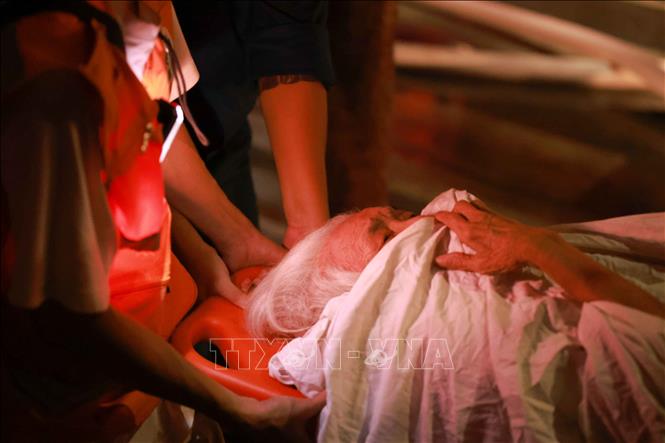 Đưa người bị thương ra khỏi vùng nguy hiểm. Ảnh: Thanh Tùng - TTXVN