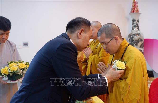 Nghi thức cài hoa hồng cùng nhớ về cha mẹ, tưởng niệm tới công đức sinh thành bao la như trời biển tại Đại lễ Vu Lan - Báo ân báo hiếu. Ảnh: Anh Tuấn - TTXVN