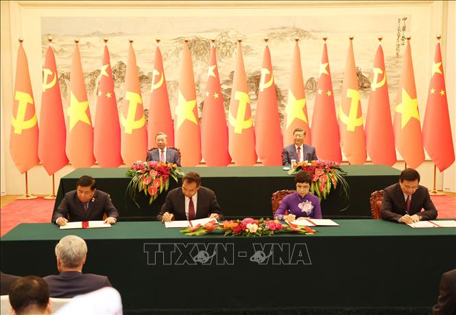 Lễ ký Thỏa thuận hợp tác nghiệp vụ giữa Thông tấn xã Việt Nam với Tân Hoa xã (bên phải) và Bản ghi nhớ về thúc đẩy các dự án hợp tác phát triển trong lĩnh vực xã hội, dân sinh giữa Bộ Kế hoạch và Đầu tư Việt Nam và Tổng cục Hợp tác phát triển quốc tế quốc gia Trung Quốc (bên trái). Ảnh: Trí Dũng – TTXVN