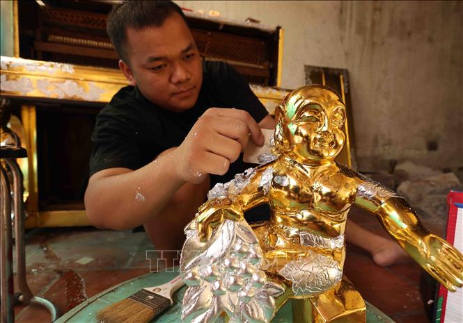 Dát vàng, bạc, quỳ lên sản phẩm ở làng nghề truyền thống Kiêu Kỵ. Ảnh: Vũ Sinh - TTXVN