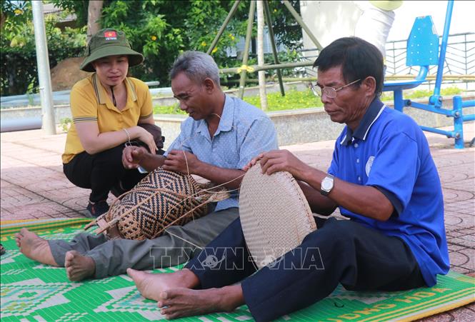 Thế hệ trẻ Khánh Sơn học tập những già làng, trưởng bản công việc nghề thủ công. Ảnh: Phan Sáu - TTXVN