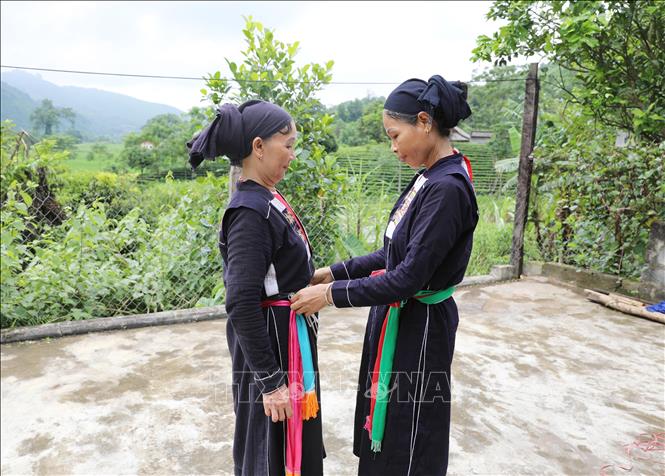 Chuẩn bị trang phục truyền thống của người Sán Chay để hát Sấng Cọ. Ảnh: Hoàng Nguyên - TTXVN