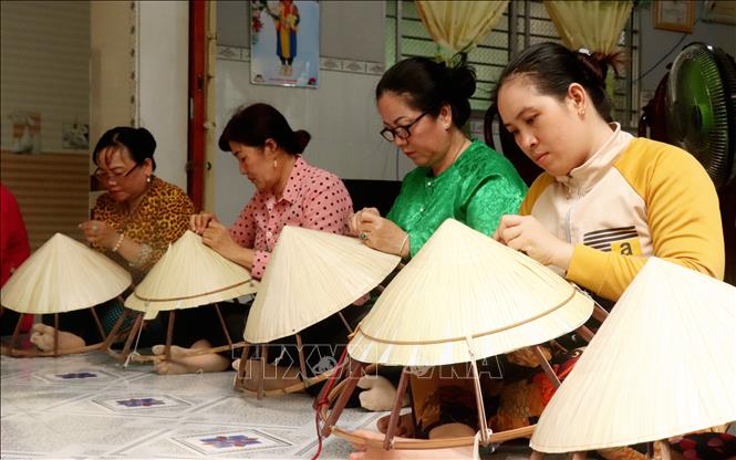 Làm nón lá giúp phụ nữ Thới Lai, Cần Thơ kiếm thêm thu nhập lúc nhàn rỗi. Ảnh: Thu Hiền - TTXVN