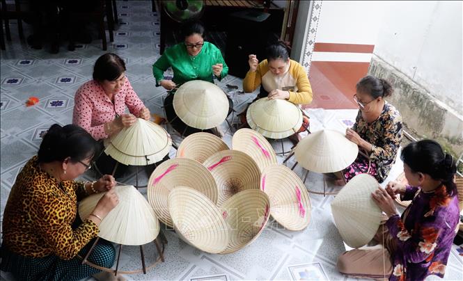 Phụ nữ ở thị trấn Thới Lai (Cần Thơ) chằm nón lá. Ảnh: Thu Hiền - TTXVN