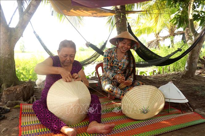 Người trẻ kế tiếp nghề chằm nón lá tại thị trấn Thới Lai (Cần Thơ). Ảnh: Thu Hiền - TTXVN