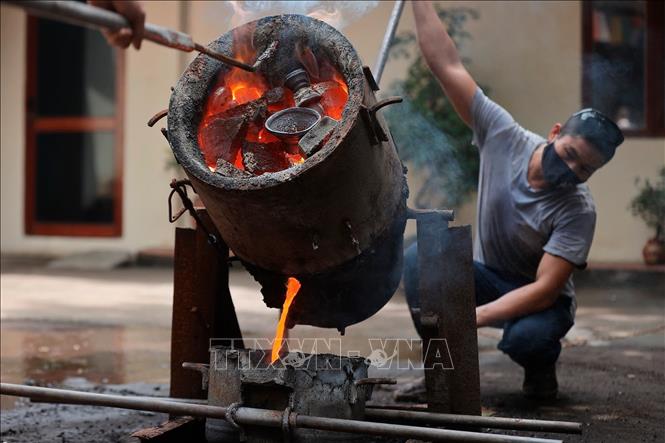 Đồng được nấu chảy ở nhiệt độ thích hợp trước khi đổ vào khuôn. Ảnh: Minh Quyết - TTXVN