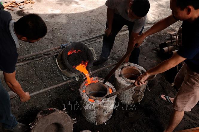 Đồng được nấu chảy và đổ vào khuôn. Ảnh: Minh Quyết - TTXVN