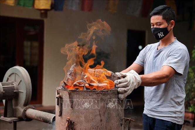 Người thợ chuẩn bị lò để nấu chảy đồng nguyên chất trước khi đúc. Ảnh: Minh Quyết - TTXVN
