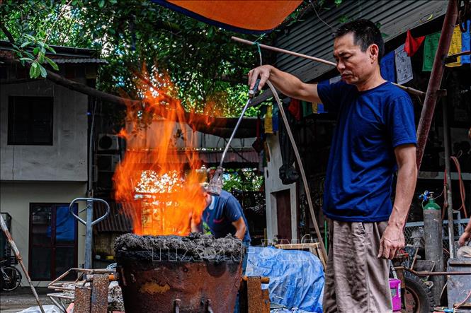 Người thợ chuẩn bị lò để nấu chảy đồng nguyên chất trước khi đúc. Ảnh: Phạm Tuấn Anh - TTXVN