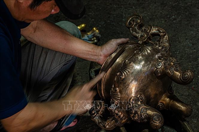 Bản tay khéo léo của người thợ Ngũ Xã tỉ mỉ chạm khắc từng đường nét tinh xảo cho sản phẩm đồng đúc. Ảnh: Phạm Tuấn Anh - TTXVN