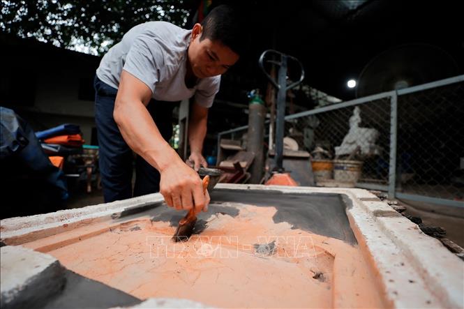 Người thợ tỉ mỉ từ khâu làm khuôn cho sản phẩm. Ảnh: Minh Quyết - TTXVN