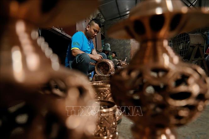 Sản phẩm sau khi đúc xong được người thợ làm bóng, hoàn thiện thủ công qua các công đoạn. Ảnh: Minh Quyết - TTXVN