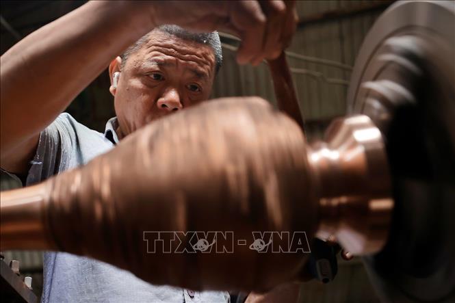 Sản phẩm sau khi đúc xong được người thợ làm bóng, hoàn thiện thủ công qua các công đoạn. Ảnh: Minh Quyết - TTXVN