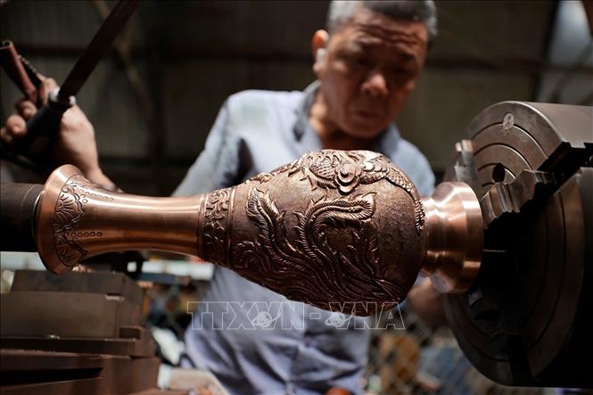 Sản phẩm sau khi đúc xong được người thợ làm bóng, hoàn thiện thủ công qua các công đoạn. Ảnh: Minh Quyết - TTXVN
