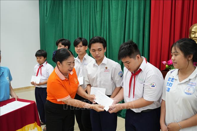 Trao học bổng cho học sinh có hoàn cảnh khó khăn. Ảnh: Huỳnh Phúc Hậu - TTXVN