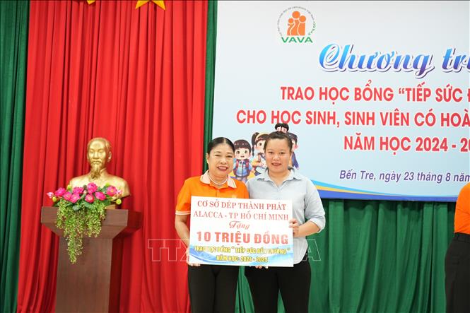 Tiếp nhận bảng tượng trưng kinh phí hỗ trợ từ các nhà tài trợ. Ảnh: Huỳnh Phúc Hậu - TTXVN