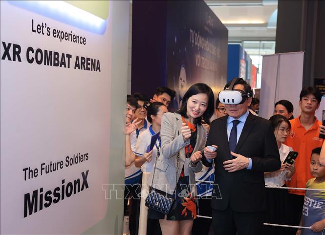 Tran Luu Quang, head of the Party Central Committee’s Economic Commission and Deputy Prime Minister, experiences virtual reality goggles at the AI expo. VNA Photo: Hoàng Hiếu