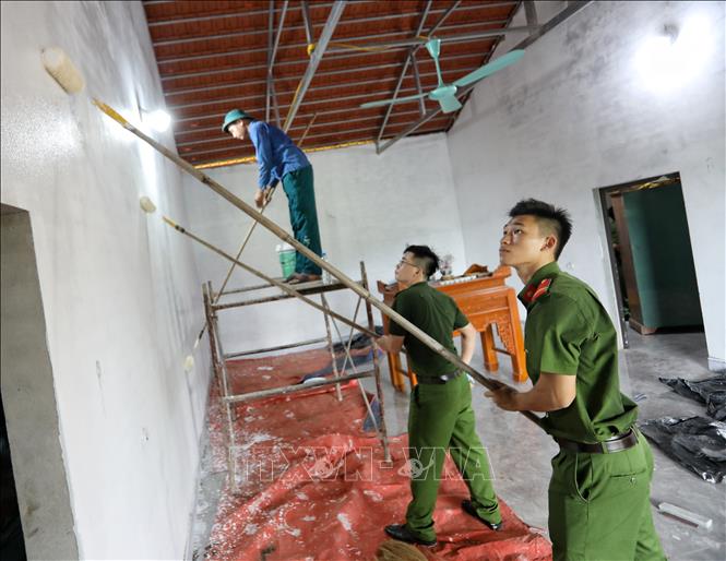 Trong ảnh: Cán bộ, chiến sỹ công an tỉnh Bắc Giang thi công sơn nhà cho hộ gia đình bà Lâm Thị Tắc, dân tộc Sán Chí, xã Sa Lý, hộ nghèo. Ảnh: Danh Lam -TTXVN 