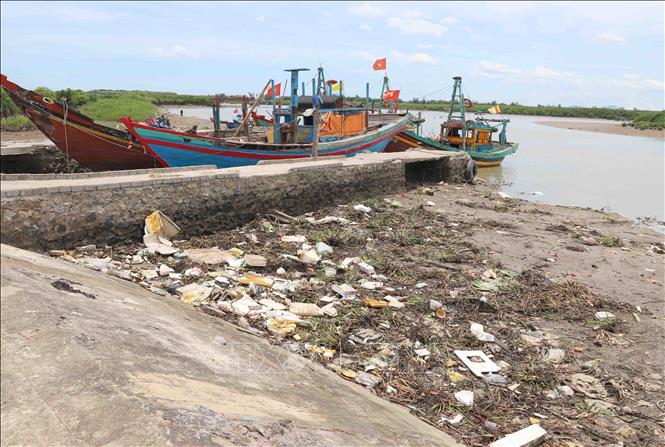 Rác thải mắc cạn trên bờ sông Diễn Thủy. Ảnh: Xuân Tiến - TTXVN 