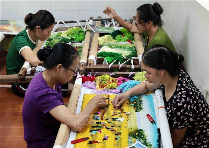 Các nghệ nhân tại cơ sở thêu Đức Tôn ở phố Tía, xã Thắng Lợi cần mẫn với sản phẩm tranh thêu phong cảnh. Ảnh: Trần Việt - TTXVN