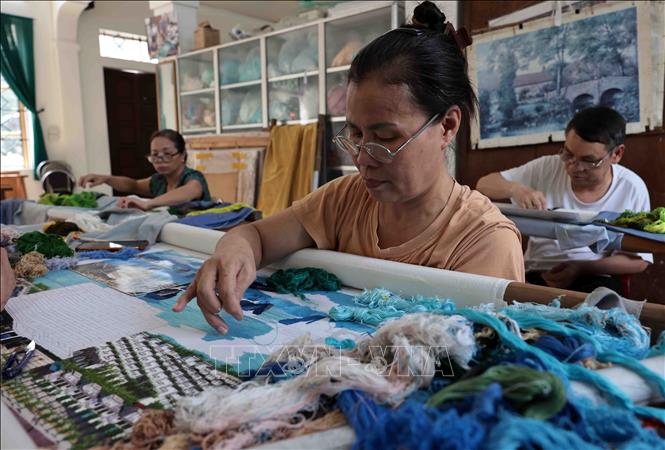 Sản phẩm được tư duy theo xu hướng hiện đại qua phương pháp thêu tay truyền thống. Ảnh: Trần Việt - TTXVN