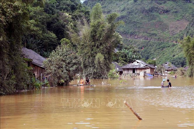 Nhân dân bản Phé, xã Tông Cọ phải di chuyển bằng bè làm bằng luồng khi bị ngập lụt. Ảnh: Quang Quyết - TTXVN