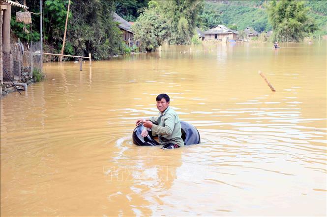 Nhân dân bản Phé, xã Tông Cọ phải di chuyển bằng phao làm từ xăm ô tô để đi lấy thức ăn khi mưa lũ, ngập úng xảy ra. Ảnh: Quang Quyết - TTXVN