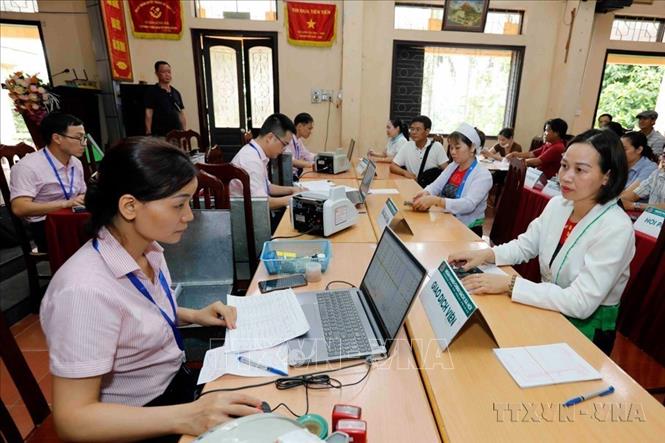 Cùng với phát triển về kinh tế, Đảng và Chính phủ có những chủ trương, chính sách đồng bộ, huy động sức mạnh tổng hợp toàn xã hội để thực hiện chương trình mục tiêu quốc gia về xoá đói giảm nghèo, giải quyết việc làm và ổn định xã hội. Trong ảnh: Một buổi giao dịch cho vay tại điểm giao dịch xã Ba Trại, huyện Ba Vì, Hà Nội. Ảnh: Trần Việt - TTXVN
