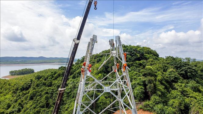 Công nhân Công ty Truyền tải điện 3 lắp dựng tại vị trí cột 21 địa bàn huyện Quỳnh Lưu (Nghệ An), đoạn Quỳnh Lưu-Thanh Hóa. Ảnh: Huy Hùng – TTXVN