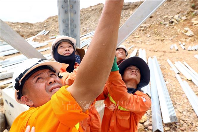 Công nhân Công ty Truyền tải điện 3 lắp dựng tại vị trí cột 21 địa bàn huyện Quỳnh Lưu (Nghệ An) đoạn Quỳnh Lưu-Thanh Hóa. Ảnh: Huy Hùng - TTXVN