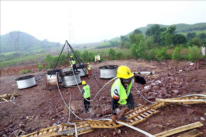 Công nhân Công ty Cổ phần Tập đoàn 1 thi công kéo dây trong mưa tại khoảng néo 134-137 trên địa bàn huyện Cẩm Xuyên (Hà Tĩnh) đoạn Quảng Trạch - Quỳnh Lưu. Ảnh: Huy Hùng – TTXVN