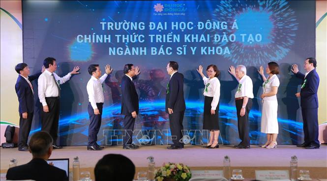 Các đại biểu thực hiện nghi thức tại Lễ công bố mở đào tạo ngành Bác sĩ y khoa và cử nhân Kỹ thuật phục hồi chức năng trình độ đại học tại trường Đại học Đông Á. Ảnh: Văn Dũng - TTXVN