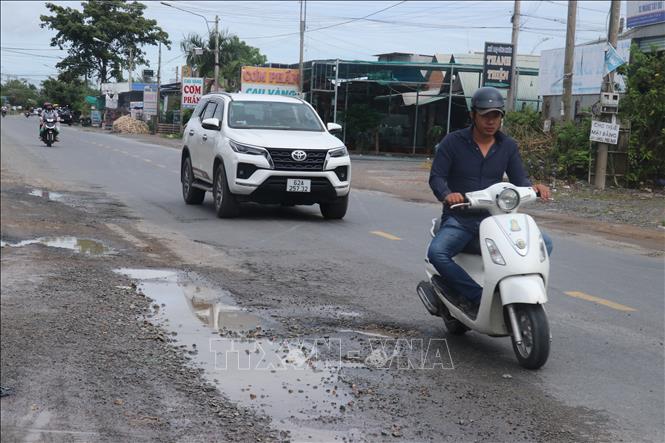 Sau 25 năm đưa vào sử dụng, nhiều đoạn trên Quốc lộ 62 hư hỏng, xuống cấp gây khó khăn trong việc lưu thông. Ảnh: Bùi Giang - TTXVN