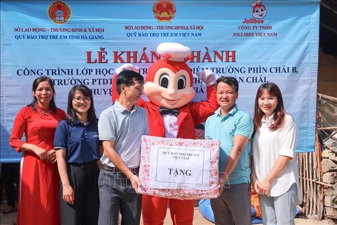 Lãnh đạo Quỹ Bảo trợ trẻ em Việt Nam trao quà cho đại diện trường Phìn Chải B (Đồng Văn, Hà Giang). Ảnh: Hoàng Hiếu - TTXVN