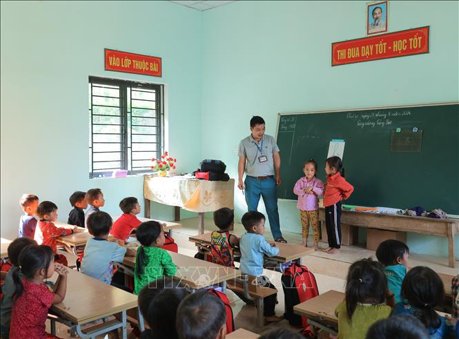 Thầy Vàng Mí Dính với các em học sinh lớp 1 tại điểm trường mới (điểm trường Phìn Chải B thuộc Trường PTDTBT TH&THCS Vần Chải, Đồng Văn, Hà Giang). Ảnh: Hoàng Hiếu - TTXVN