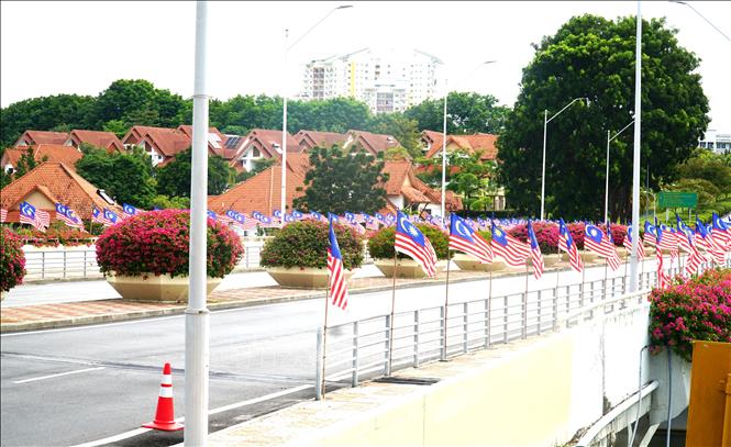 Quốc kỳ và hoa giấy được trang hoàng dọc hai bên đường phố. Ảnh: Hằng Linh-PV TTXVN tại Kuala Lumpur 
