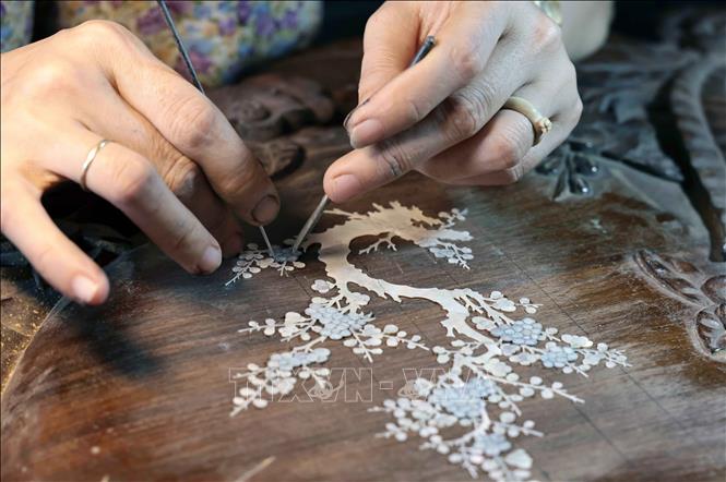 Ghép mẫu trên gỗ. Ảnh: Trần Việt - TTXVN