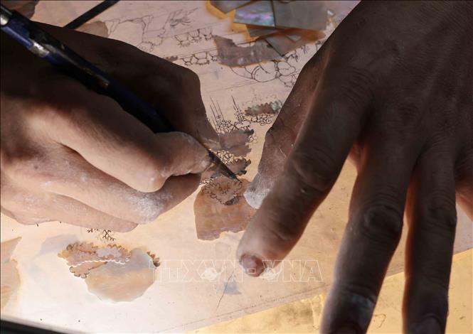 Các nghệ nhân vẽ tạo hình trên vỏ trai, ốc. Ảnh: Trần Việt - TTXVN