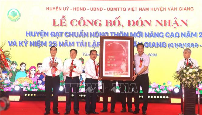 Bí thư Tỉnh ủy Hưng Yên Nguyễn Hữu Nghĩa (bên phải) tặng huyện Văn Giang bức tranh chân dung Chủ tịch Hồ Chí Minh. Ảnh: Mai Ngoan - TTXVN