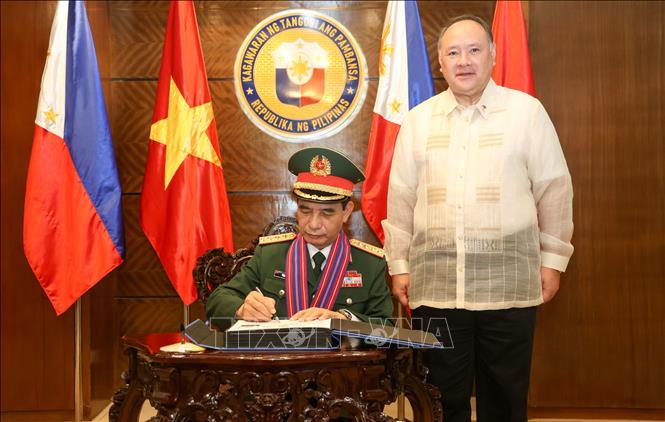 Bộ trưởng Quốc phòng Phan Văn Giang ký sổ vàng lưu niệm tại Bộ Quốc phòng Philippines. Ảnh: Lê Dương-P/v TTXVN tại ĐNA