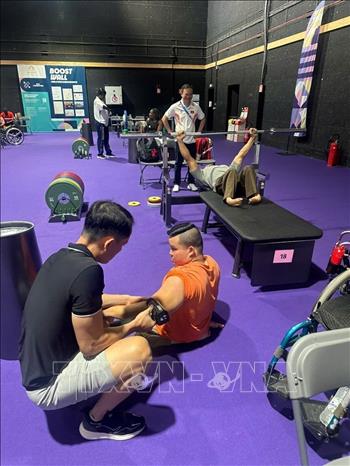 Bác sỹ Nguyễn Việt Tuấn (áo đen) chăm sóc cho lực sỹ Nguyễn Bình An. Ảnh: TTXVN phát