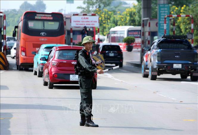 Lực lượng CSCĐ được tăng cường tham gia hỗ trợ điều tiết, phân luồng giao thông tại khu vực trạm thu phí Pháp Vân - Cầu Giẽ. Ảnh: Phạm Kiên - TTXVN