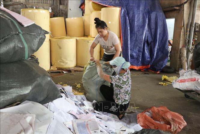 Các cơ sở sản xuất giấy trong khu dân cư tại Phong Khê đóng cửa, dừng hoạt động để bảo vệ môi trường, còn một số ít người làm thuê phân loại, xử lý giấy để bán cho các công ty tái chế khác. Ảnh: Thanh Thương- TTXVN