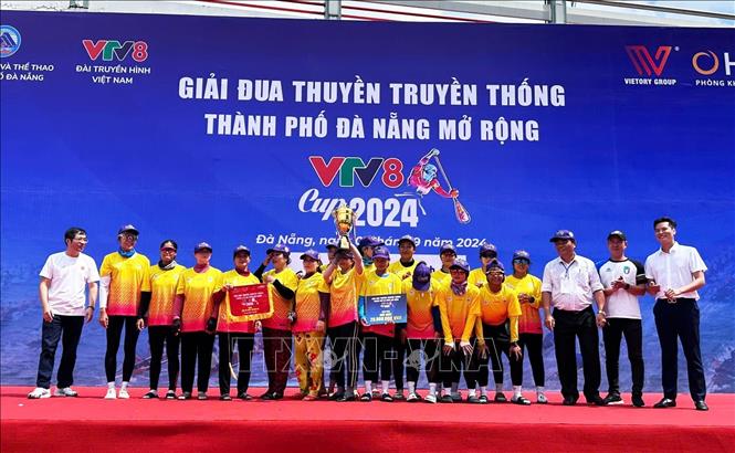 Ban tổ chức trao giải Nhất cho đội thuyền nữ Trung tâm Văn hóa quận Hải Châu. Ảnh: Trần Lê Lâm - TTXVN 